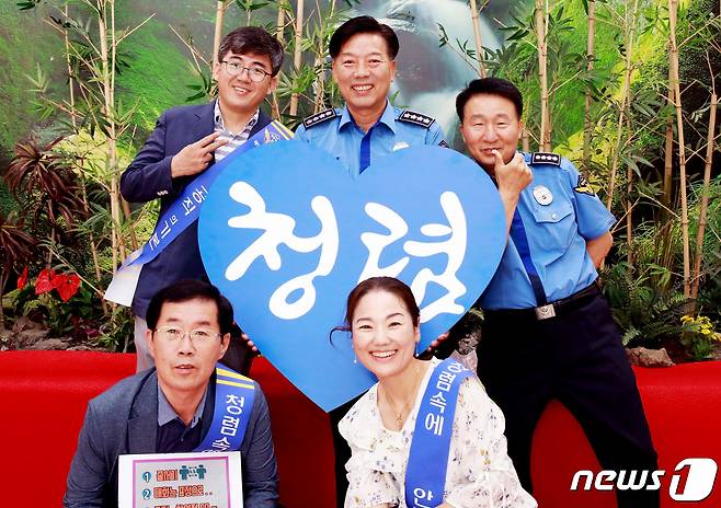 김홍희 해양경찰청장(윗줄 왼쪽에서 두번째)이 직원들과 청렴캠페인 후 기념사진을 촬영하고 있다.(해경청제공)© 뉴스1