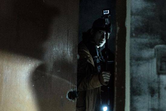 영화 '곤지암'에서 한 배우가 방송 장비로 폐병원 내부를 촬영하고 있다.