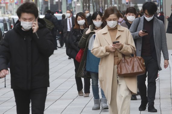 지난 26일 일본 도쿄 긴자 거리. 마스크를 쓴 사람들이 어디론가로 향하고 있다. AP뉴시스