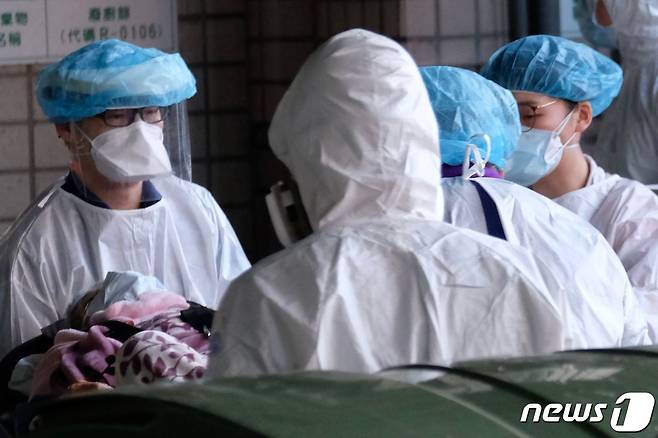 최근 코로나19 집단감염이 발생한 대만 타오위안 종합병원에서 의료진이 환자를 옮기고 있다. © AFP=뉴스1