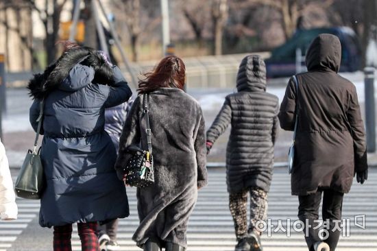 눈이 그치고 강풍이 불고 있는 28일 서울 여의도에서 시민들이 두꺼운 외투를 입고 이동하고 있다./강진형 기자aymsdream@