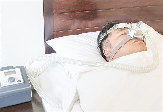 수면무호흡증 환자가 양압기를 착용한채 잠을 자고 있다. 한국일보 자료사진