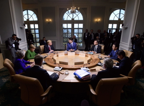 지난 2018년 6월 8일 주요 7개국(G7) 정상회의가 캐나다 퀘벡주 샤를부아에서 개막, 참석자들이 회담을 열고 있다. 쥐스탱 트뤼도 캐나다 총리(뒤 가운데·시계방향), 에마뉘엘 마크롱 프랑스 대통령, 아베 신조 일본 총리, 주세페 콘테 이탈리아 총리, 장클로드 융커 유럽연합(EU) 집행위원장, 도날트 투스크 EU 정상회의 상임의장, 테리사 메이 영국 총리, 앙겔라 메르켈 독일 총리, 도널드 트럼프 미국 대통령. AP=연합뉴스