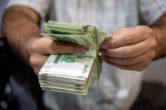 한국 시중 은행에 묶여 있는 이란의 자금을 돌려주기 위해 외교부가 워킹그룹을 조직했다. 사진은 2019년 8월 1일 이란 테헤란의 한 세일즈맨이 이란 화폐를 세고 있는 장면. [로이터=연합뉴스]