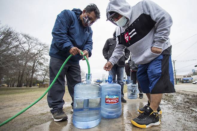 18일(현지시간) 미국 텍사스주 휴스턴에서 식수난을 겪고 있는 주민들이 물을 공급받고 있는 모습. [AP]