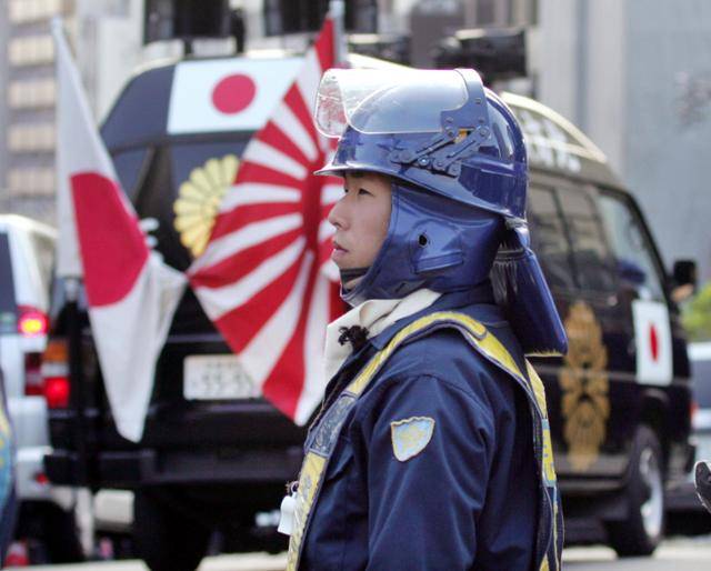 2005년 11월 20일 블라디미르 푸틴 러시아 대통령이 일본을 공식 방문한 이날 도쿄의 러시아 대사관 앞에서 한 시위진압 경찰이 북방 4개섬 반환을 요구하는 극우단체의 시위차량을 지켜보고 있다. 도쿄=로이터 연합뉴스