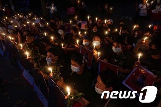 미얀마 군부에 대항하는 시위대가 양곤 주재 미국 대사관 앞에서 촛불시위를 벌이고 있다. © AFP=뉴스1