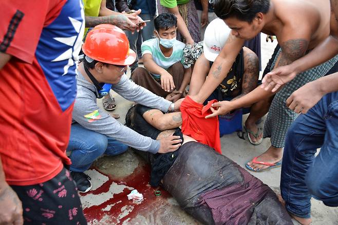 지난 20일(현지시간) 미얀마 제2도시 만달레이에서 경찰의 발포로 부상을 입은 한 시민이 쓰러져 있다.  만달레이|로이터연합뉴스
