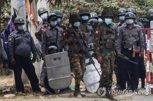저격용 소총을 들고 만달레이 시위대와 대치하는 군인(가운데). 2021.2.20 [AFP=연합뉴스]