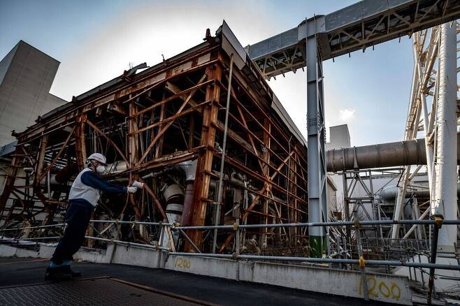일본 도쿄전력 직원이 21일 후쿠시마현의 제1 원전의 원자로 격납용기 옆에서 방사능 농도를 측정하고 있다. 오쿠마/AFP 연합뉴스