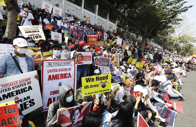 미얀마 옛 수도 양곤의 미국 대사관 앞에서 16일(현지시간) 시위대가 군부 쿠데타를 규탄하는 내용의 플래카드를 들고 시위를 벌이고 있다. 연합뉴스