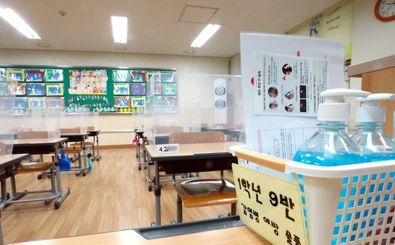 서울 서초구의 한 초등학교 교실에 방역 물품이 비치돼 있다. 비대면 수업에 따른 부작용을 우려하는 학부모들은 교문을 열기를 바라고 있다. [연합뉴스]