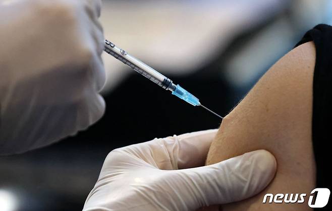 지난달 21일(현지시간) 이스라엘 예루살렘에 있는 신종 코로나바이러스 감염증(코로나19) 백신 센터에서 의료진이 환자에게 백신을 접종하고 있다. © AFP=뉴스1