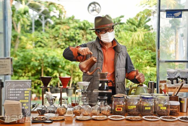 임영주 담양커피농장 대표가 커피나무가 자라고 있는 농장을 배경으로 커피를 내리고 있다.