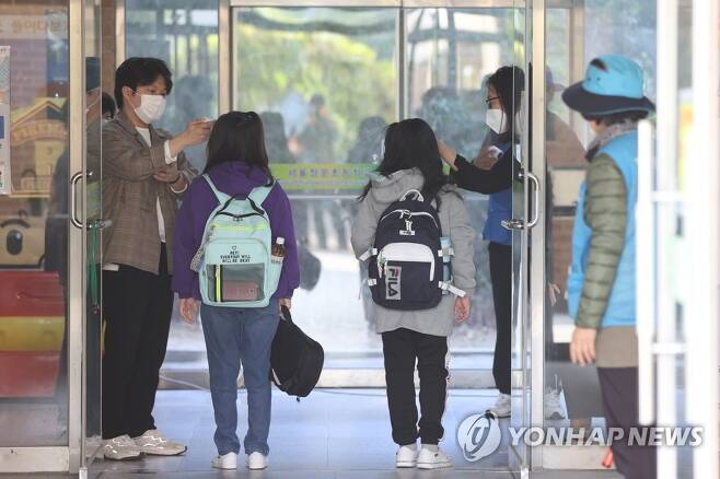서울의 한 초등학교에서 학생들이 교실로 들어가기 전 발열 체크를 받고 있다. [연합뉴스 자료사진]