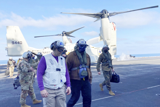 항공모함 위의 美 국방장관 : 조 바이든 미국 행정부가 25일 시리아에서 친이란 민병대에 대한 첫 공습을 단행한 가운데 로이드 오스틴(가운데) 미국 국방장관이 미 항공모함 니미츠호 갑판을 걸어가고 있다. AP연합뉴스