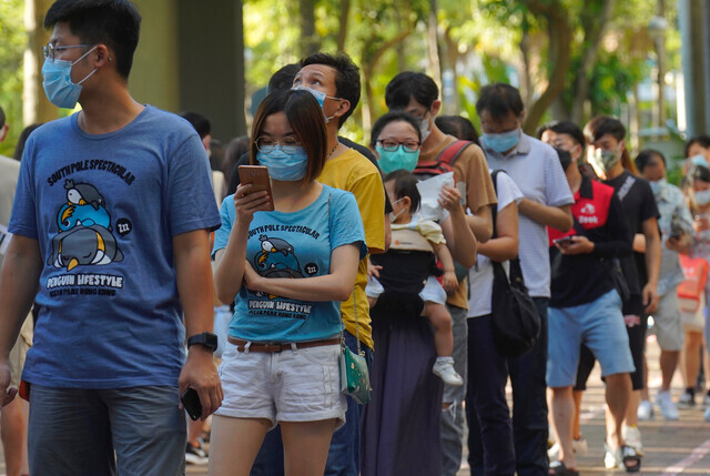 지난해 7월12일 홍콩 범민주 진영 입법의원 선거 후보 선출을 위해 민주동력 주도로 열린 자체 경선에 참여하기 위해 마스크를 쓴 홍콩 시민들이 기다랗게 줄을 늘어서 있다. 홍콩/AP 연합뉴스