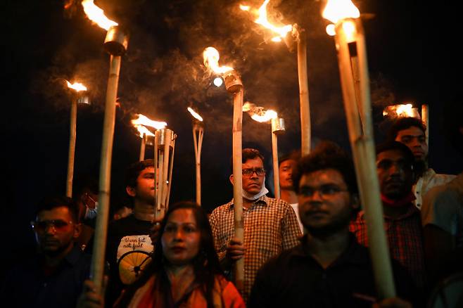 ‘표현의 자유를 묻는다’ 방글라데시 시민들이 지난 26일 수도 다카에서 소셜미디어를 통해 정부를 비판한 혐의로 수감 중에 사망한 작가 무슈타크 아메드의 죽음에 항의하며 횃불을 들고 있다.    다카 | 로이터연합뉴스