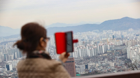 한 시민이 서울 도심 아파트 밀집 지역을 촬영하고 있다. <연합뉴스>