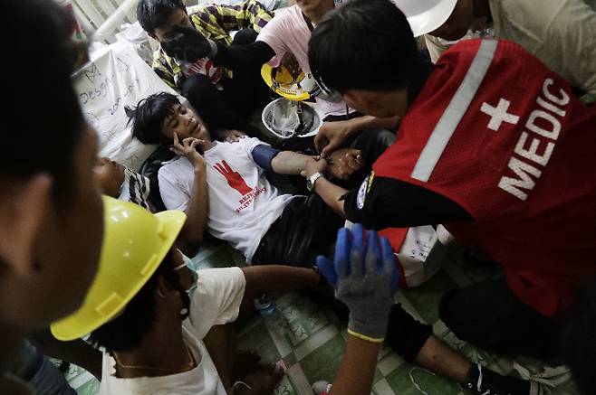 3일(현지시간) 미얀마 최대 도시 양곤의 쿠데타 반대 시위 현장에서 의료진이 부상자를 치료하고 있다. 연합뉴스
