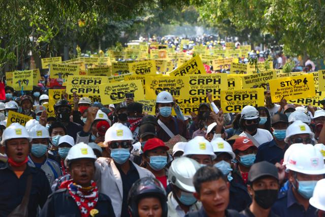 미얀마의 지방 도시 만달레이에서 6일 반군부 시위대가 헬멧과 마스크를 착용하고 거리를 행진하고 있다. 만달레이=AP 연합뉴스