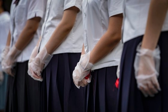 일본 후쿠오카 시립 중학교 69곳을 조사한 결과 불합리한 복장 및 두발 규정 등이 지적됐다. 사진은 일본 학생들이 교복을 입은 채 코로나 19 방지를 위해 위생 장갑을 낀 모습/EPA=연합