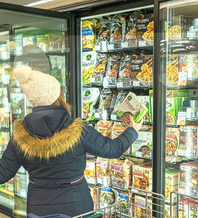 미국의 대형마트에서 한 소비자가 아시안푸드 브랜드들이 별도로 진열된 아시아푸드존에서 비비고 비빔밥 제품을 고르고 있다.(CJ제일제당 제공) © 뉴스1