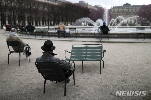 [AP/뉴시스] 3월22일 프랑스 파리의 팔레 르와이알 정원에서 시민들이 띄엄띄엄 의자에 앉아 분수를 바라보고 있다. 파리 등 10여 개 현이 주말 록다운을 추가 실시하고 있다.