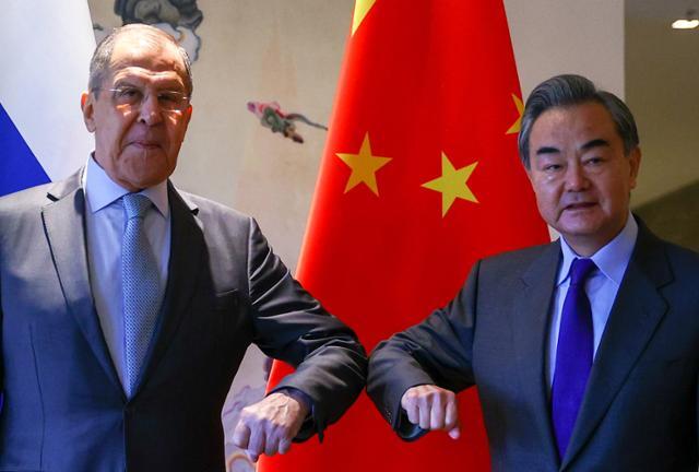 왕이(오른쪽) 중국 외교부장이 지난달 23일 광시좡족자치구 구이린에서 세르게이 라브로프 러시아 외무장관과 공동성명 발표에 앞서 팔꿈치 인사를 하고 있다. 구이린=EPA 연합뉴스