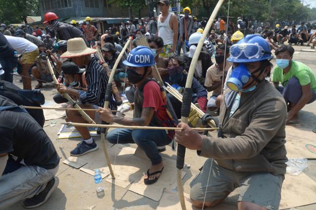 지난달 27일 미얀마 양곤에서 시위대 일부가 활과 화살을 들고 있다. 양곤=AP 연합뉴스