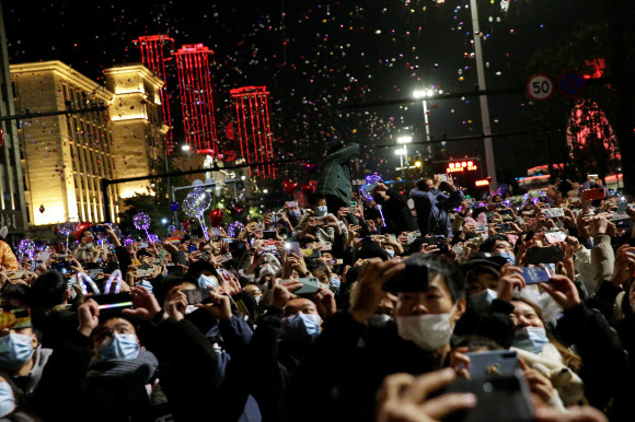 코로나19 감염병의 진원지인 중국 우한 시민들이 31일 새해 전야 행사에 운집해 있다. 마스크를 쓰긴 했지만 한국이 5명 이상 모이지 않게 하는 등 강력한 사회적 거리 두기를 시행하는 것과 대조를 이룬다.우한 로이터 연합뉴스