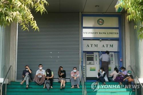 셔터를 내린 양곤 미먀와디 은행의 ATM에서 현금을 찾는 시민들.[AFP=연합뉴스 자료사진]