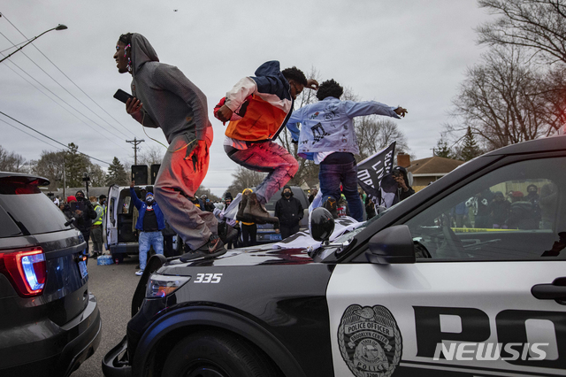 [브루클린센터=AP/뉴시스]11일(현지시간) 미국 미네소타주 브루클린센터에서 교통 단속 중 한 경관이 흑인에게 총격을 가해 숨지게 한 사건이 발생하자 이에 항의하는 시위대가 경찰차에 올라 항의 시위를 벌이고 있다. 2021.04.12.