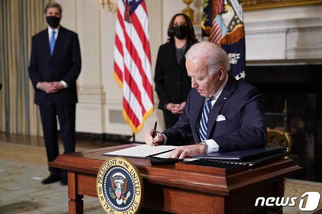 조 바이든 미국 대통령이 2021년 1월27일(현지시간) 워싱턴 백악관에서 카멀라 해리스 부통령, 존 케리 기후 특사가 지켜보는 가운데 기후변화 관련 행정명령에 서명을 하고 있다. © AFP=뉴스1 © News1 우동명 기자