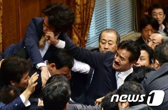 2015년 일본 안보 법제 제·개정안 날치기 통과를 주도한 자민당의 사토 마사히사 참의원이 당시 주먹으로 민주당 소속의 고니시 히로유키(小西洋之, 왼쪽) 의원의 얼굴을 밀어내고 있다. © AFP=뉴스1