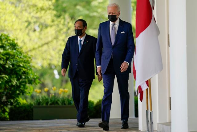 조 바이든(오른쪽) 미국 대통령과 스가 요시히데 일본 총리가 16일 백악관에서 정상 회담을 마치고 공동 기자회견이 열리는 로즈가든으로 이동하고 있다. 워싱턴=AP 뉴시스