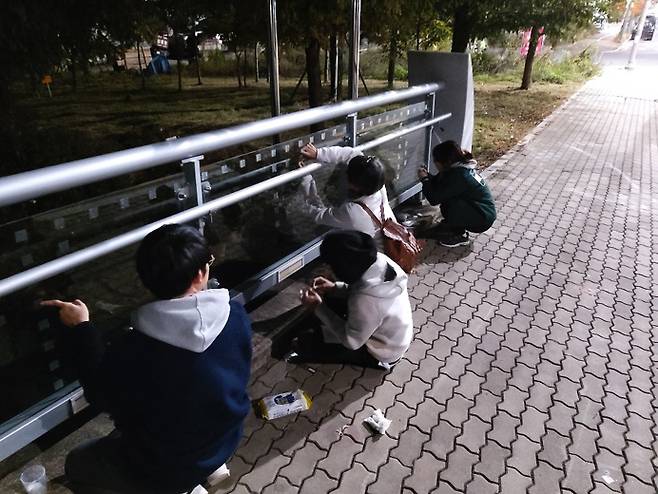 2019년 디지스트 생태 동아리 `잡다` 학생들이 학교 정문 앞 `과학기술교`에서 조류 충돌 방지 스티커를 붙이고 있다. [사진 제공 = 동아리 잡다]
