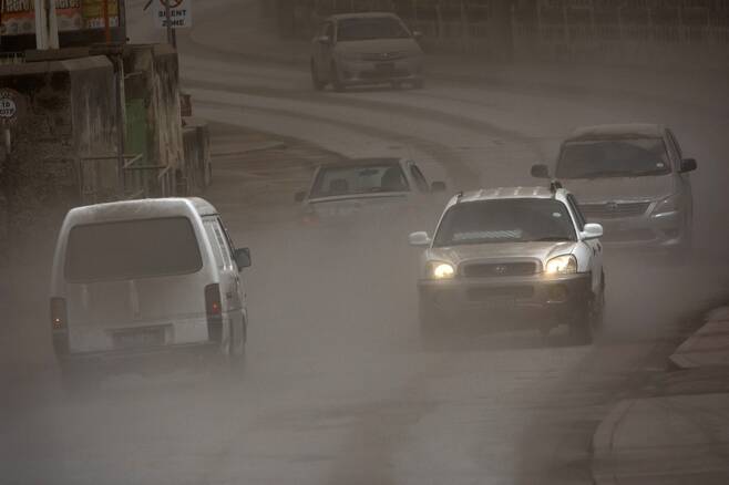 화산재가 눈처럼 쏟아진 도로를 달리는 자동차들. 사진=AP 연합뉴스