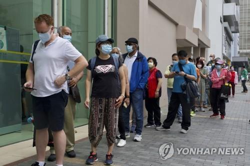 (홍콩 AP=연합뉴스) 지난 6일 홍콩의 한 신종 코로나바이러스 감염증(코로나19) 백신 접종 센터 앞에서 시민들이 줄지어 서 있다.
