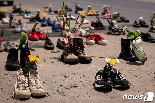 2021년 4월8일(현지시간) 미얀마 만달레이에서 군사 쿠데타를 반대하는 시위 중 꽃을 꽂아놓은 신발이 거리에 펼쳐져 있다. © AFP=뉴스1 © News1 우동명 기자