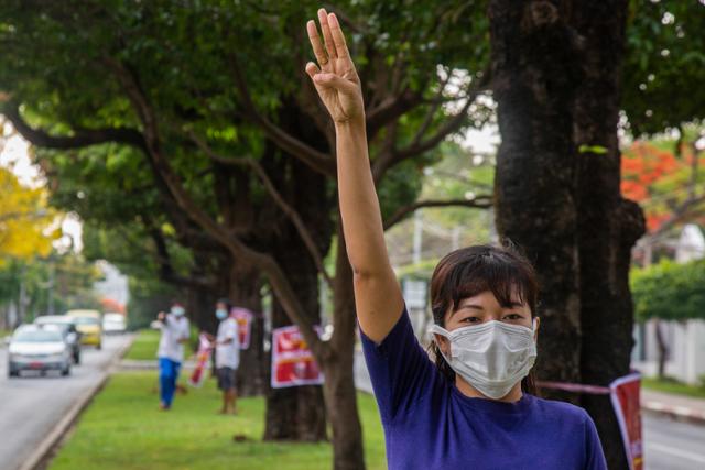 미얀마 양곤 시민이 21일 파란 옷을 입고 세 손가락 경례를 하고 있다. 양곤=AP 연합뉴스