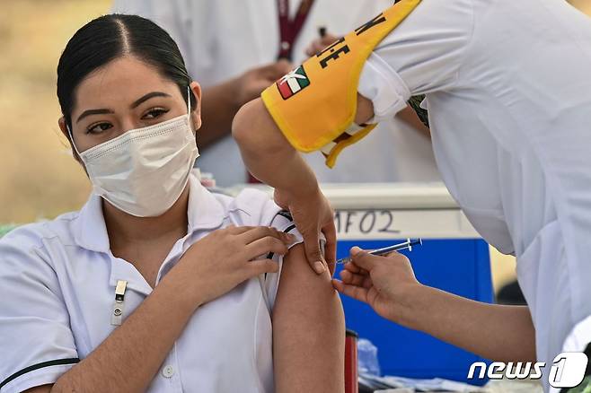 멕시코 시티에서 의료 종사원이 화이자-바이오엔테크의 코로나19 백신을 접종받고 있다. © AFP=뉴스1 © News1 우동명 기자