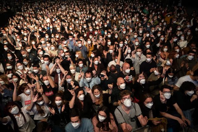 마스크를 쓴 관객들이 지난달 27일 스페인 바르셀로나의 팔라우 산 조르디 경기장에서 열린 인디밴드 '러브 오브 레즈비언' 콘서트를 사회적 거리 두기 없이 관람하고 있다. 바르셀로나=AP 뉴시스