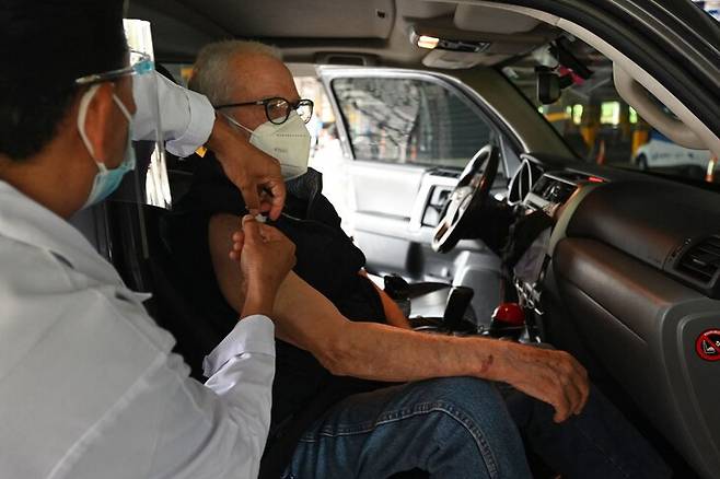 중남미 과테말라의 과테말라시에서 한 노인이 차 안에 탄 채 코로나19 백신을 맞고 있다. 과테말라/AFP 연합뉴스