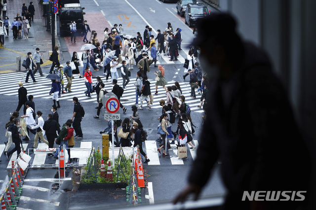 [도쿄=AP/뉴시스]지난달 29일 일본 도쿄 시부야 교차로를 한 남성이 창문 너머로 바라보고 있다. 221.05.07.