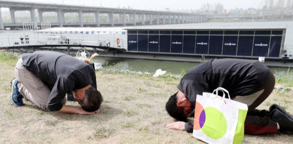 故 손정민 군의 아버지 손현씨(오른쪽)와 차종욱 민간구조사(오른쪽)가 어버이날인 8일 오후 서울 서초구 반포한강공원 택시승강장 앞에서 서로에게 절을 하고 있다. 뉴스1
