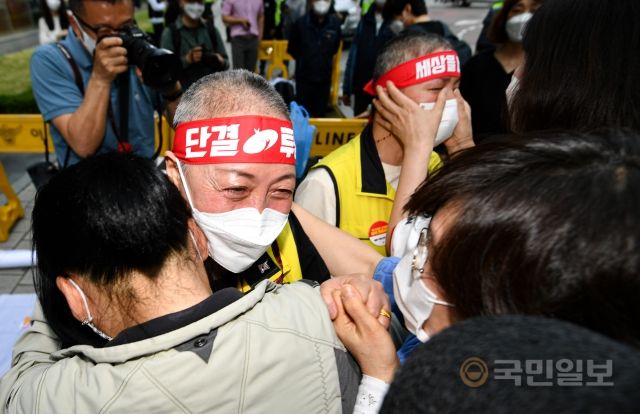 홈플러스 여성노동자들이 13일 서울 종로구 MBK파트너스 본사 앞에서 집단삭발식을 마친 뒤 서로를 위로하고 있다.