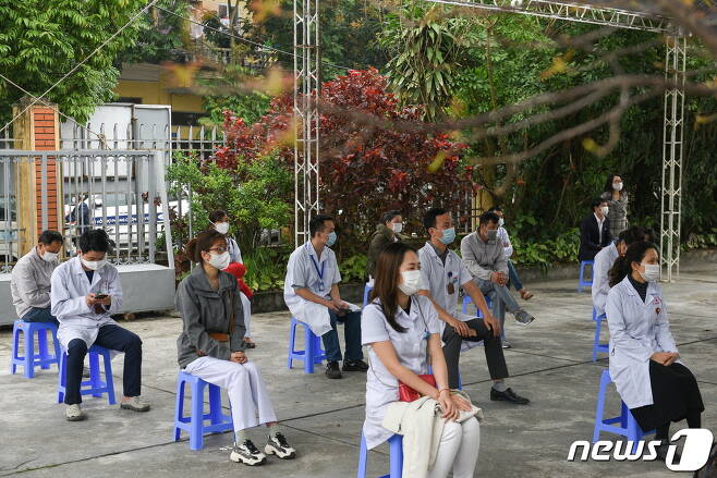 베트남 의료 종사자들이 코로나19 백신 접종을 위해 사회적 거리두기 원칙을 지키며 순서를 기다리고 있다. © 로이터=뉴스1