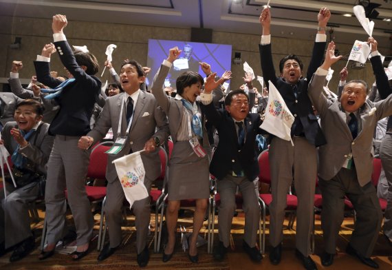 2013년 9월 당시 아베 신조 일본 총리(오른쪽에서 두 번째)와 일본 올림픽 유치 대표단이 아르헨티나에서 열린 제125회 IOC총회에서 2020년 하계 올림픽 개최지로 도쿄가 선정되자, 환호하고 있는 모습. AP뉴시스