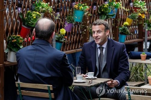 파리의 한 카페에서 만나 커피를 마시는 프랑스 대통령과 총리 (파리 AFP=연합뉴스) 에마뉘엘 마크롱(오른쪽) 프랑스 대통령이 19일(현지시간) 오전 파리의 한 카페 테라스에서 장 카스텍스 총리와 만나 커피를 마시고 있다. 2021.5.19